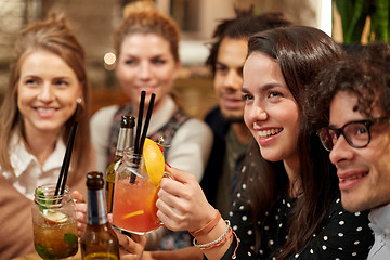 Image showing happy friends with drinks at bar or cafe