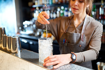 Image showing bartender with cocktail stirrer and glass at bar