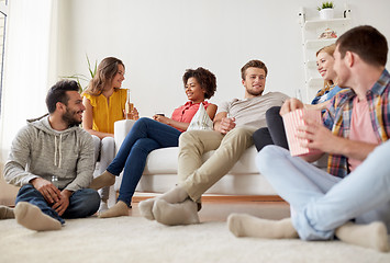 Image showing happy friends with popcorn and beer at home