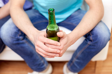 Image showing men with beer bottles sitting on sofa at home