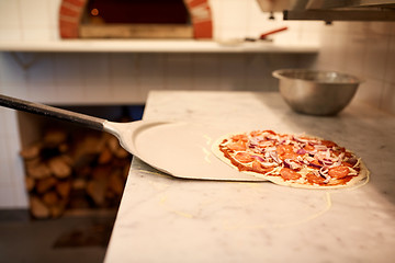 Image showing peel taking pizza off table at pizzeria