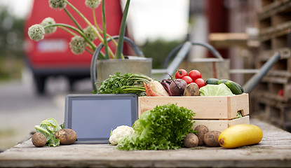 Image showing close up of vegetables with tablet pc on farm