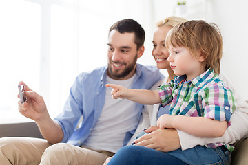 Image showing happy family with smartphone at home