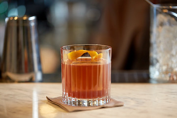 Image showing glass of cocktail with orange peel at bar