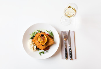 Image showing fish salad and wine glass on restaurant table