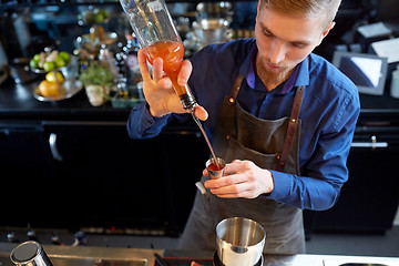 Image showing barman pouring alcohol to cocktail jigger at bar