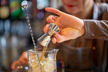 Image showing bartender with cocktail jigger and glass at bar