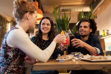 Image showing happy friends clinking drinks at bar or cafe