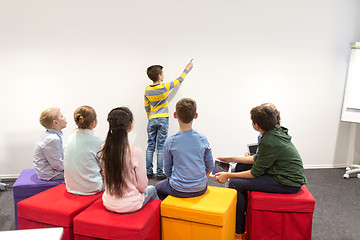 Image showing student boy with friends showing to white wall