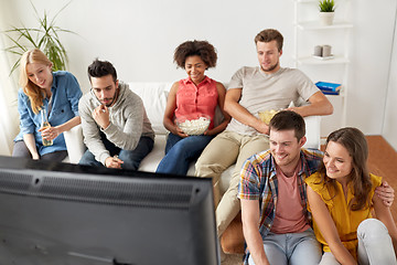 Image showing happy friends with popcorn watching tv at home