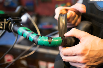 Image showing Guy fixing helm of bicycle