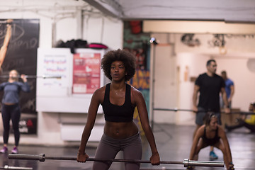 Image showing black woman lifting empty bar