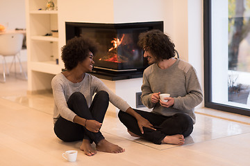 Image showing multiethnic couple  in front of fireplace