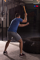 Image showing man workout with hammer and tractor tire