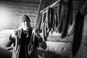 Image showing Man drying sausages bw