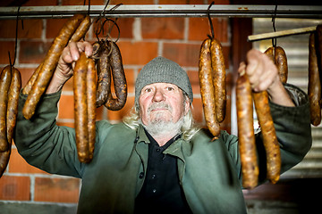 Image showing Old man with sausages