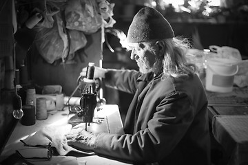 Image showing Old man sewing cloth bw