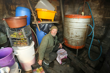 Image showing Old man making brandy