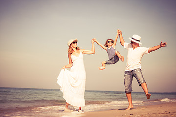 Image showing Happy family walking on the beach at the day time.