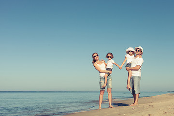 Image showing Happy family standing on the beach at the day time.