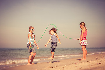 Image showing Three happy children playing on the beach