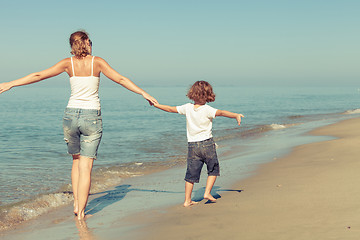 Image showing Mother and son playing on the beach at the day time.