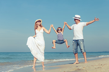 Image showing Happy family walking on the beach at the day time.