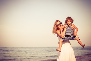 Image showing Mother and son playing on the beach at the day time.