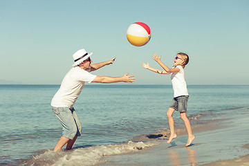 Image showing Father and daughter playing on the beach.