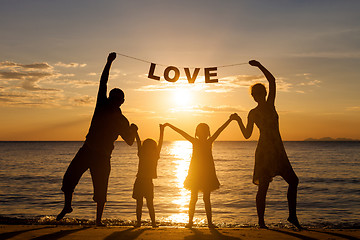 Image showing Happy family standing on the beach