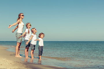 Image showing Mother and  children playing on the beach. 