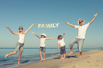 Image showing Happy family standing on the beach at the day time.