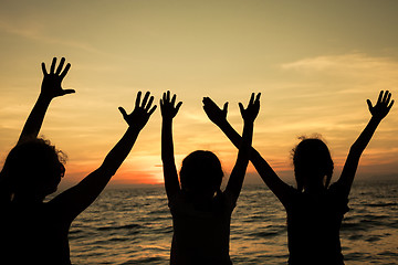 Image showing Mother and children playing on the beach at the sunset time.