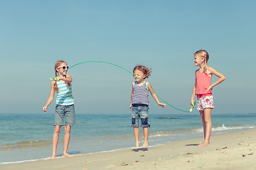 Image showing Three happy children playing on the beach