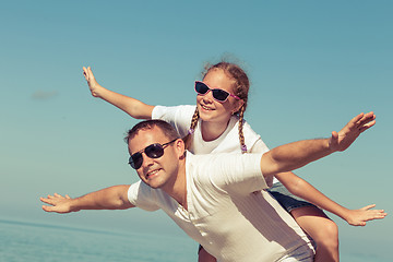 Image showing Father and daughter playing on the beach.