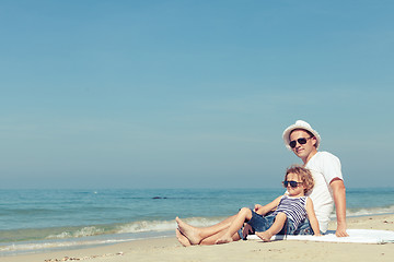 Image showing Father and son playing on the beach at the day time.