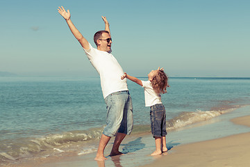 Image showing Father and son playing on the beach at the day time.