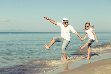 Image showing Father and daughter playing on the beach.