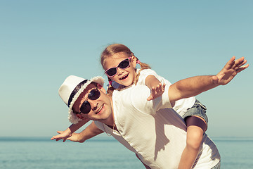 Image showing Father and daughter playing on the beach.