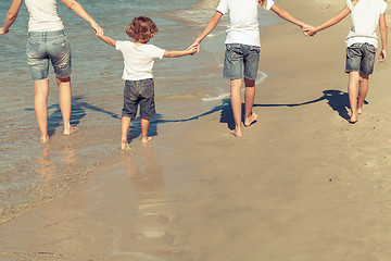 Image showing Mother and  children playing on the beach.