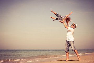 Image showing Father and son playing on the beach at the day time.