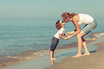 Image showing Mother and son playing on the beach at the day time.