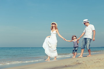 Image showing Happy family walking on the beach at the day time. 