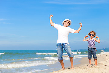 Image showing Father and son playing on the beach at the day time. 