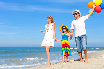 Image showing Happy family playing  with balloons on the beach at the day time