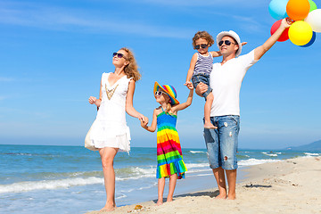 Image showing Happy family playing  with balloons on the beach at the day time