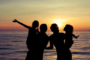 Image showing Silhouette of happy family who playing on the beach at the sunse