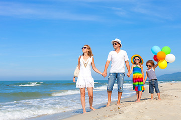 Image showing Happy family playing  with balloons on the beach at the day time