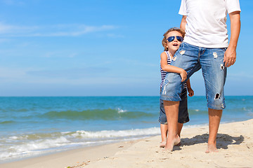 Image showing Father and son playing on the beach at the day time.