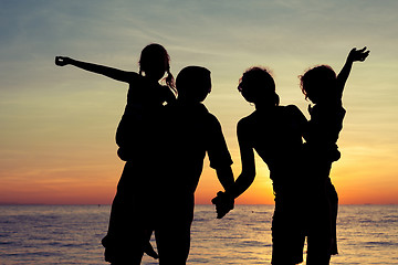 Image showing Silhouette of happy family who playing on the beach at the sunse